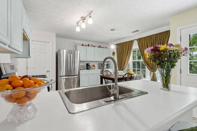 570 White Stag Ct, Suwanee, GA 30024 - kitchen with freestanding refrigerator, a sink, light countertops, and hanging light fixtures