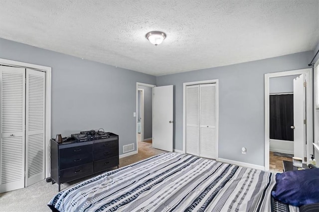 2711 Bluffton Rd, Buford, GA 30519 - bedroom with multiple closets, a textured ceiling, carpet flooring, and ensuite bath