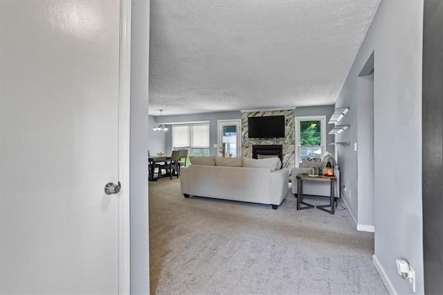 2711 Bluffton Rd, Buford, GA 30519 - carpeted living room with a textured ceiling, a stone fireplace, and a chandelier