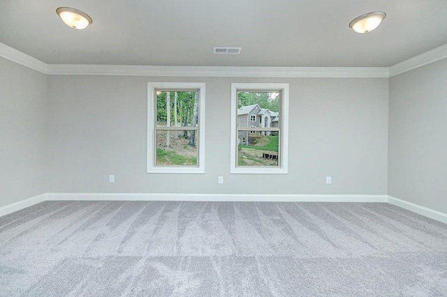 carpeted empty room featuring ornamental molding and baseboards