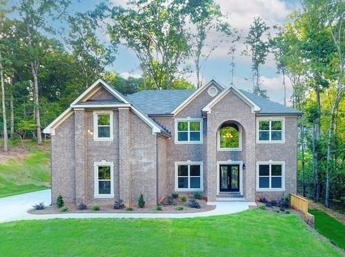 view of front facade with a front yard and brick siding