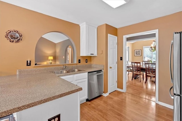1331 Red Hill Rd, Marietta, GA 30008 - kitchen featuring appliances with stainless steel finishes, white cabinetry, light wood finished floors, light countertops, and a chandelier