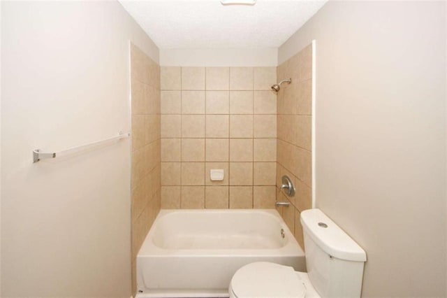 bathroom featuring tiled shower / bath combo and toilet