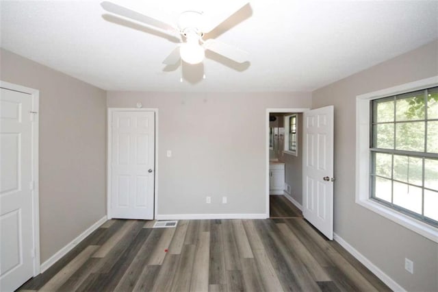 unfurnished bedroom featuring ceiling fan and dark wood-type flooring