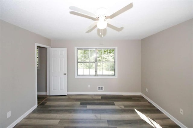 spare room featuring ceiling fan and dark wood-type flooring