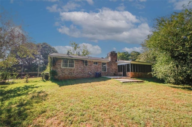 back of house with a lawn and a sunroom