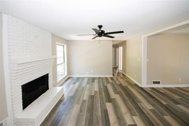 unfurnished living room with ceiling fan, dark hardwood / wood-style flooring, and a fireplace