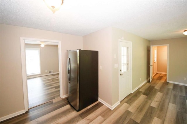 kitchen with a textured ceiling, stainless steel fridge, and dark hardwood / wood-style floors