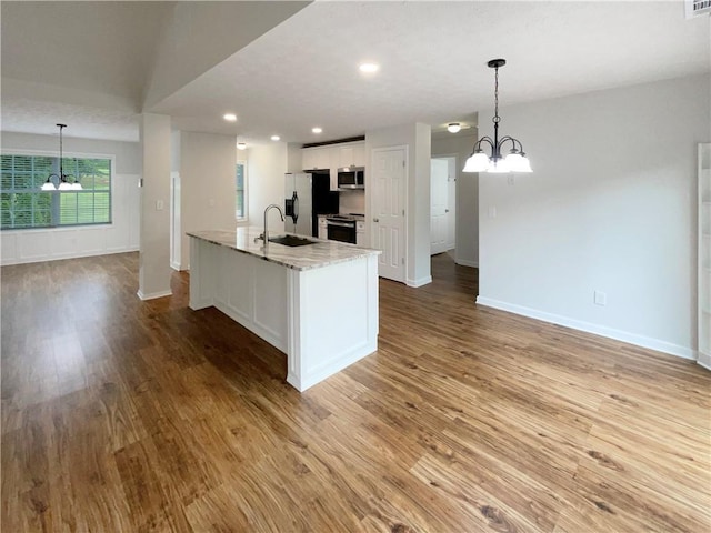 kitchen featuring an inviting chandelier, white cabinetry, baseboards, and stainless steel appliances