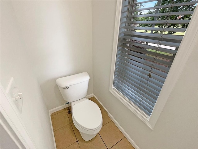 bathroom featuring toilet, baseboards, and tile patterned flooring