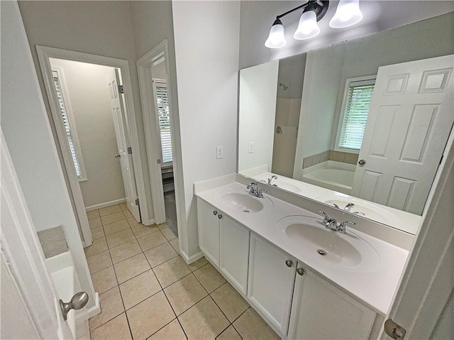 full bath with a sink, a bathing tub, and tile patterned flooring