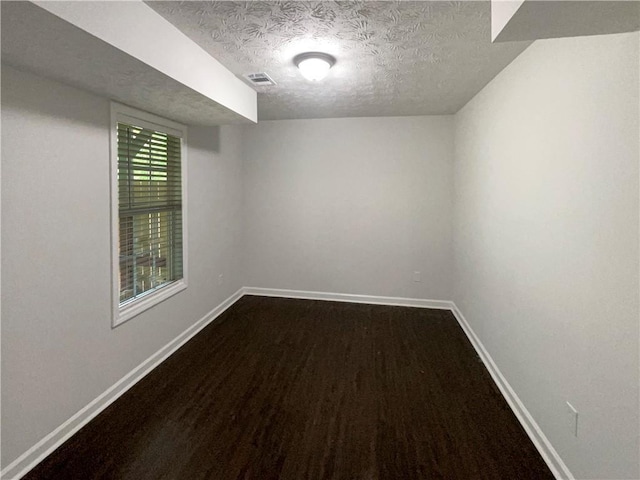 spare room featuring visible vents, a textured ceiling, and baseboards