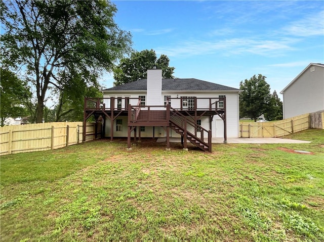 back of property featuring a fenced backyard, a yard, a deck, and stairway