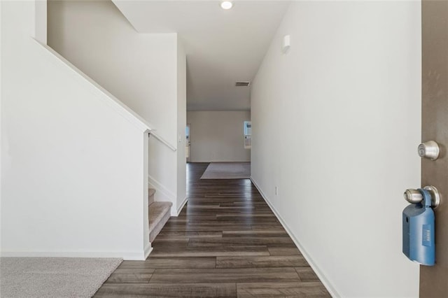 hallway featuring wood finished floors, visible vents, baseboards, and stairs