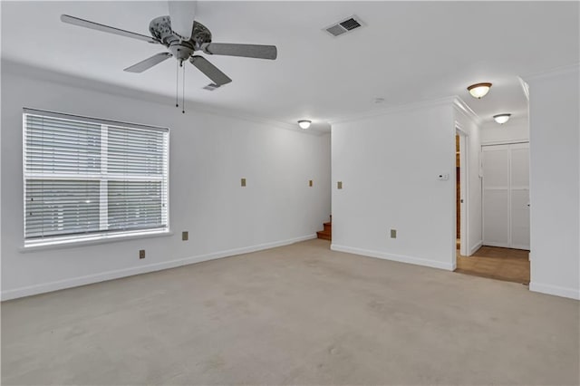 spare room featuring visible vents, light colored carpet, baseboards, and ceiling fan