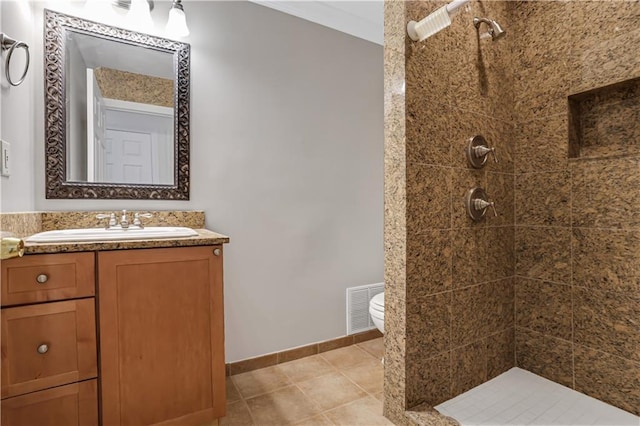full bath featuring visible vents, baseboards, toilet, vanity, and tiled shower