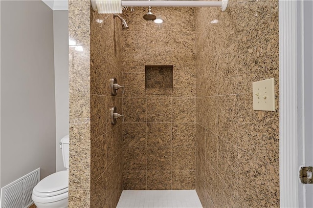 bathroom with toilet, crown molding, a shower stall, and visible vents