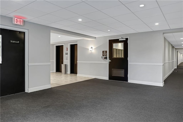 interior space featuring visible vents, baseboards, recessed lighting, a drop ceiling, and carpet flooring