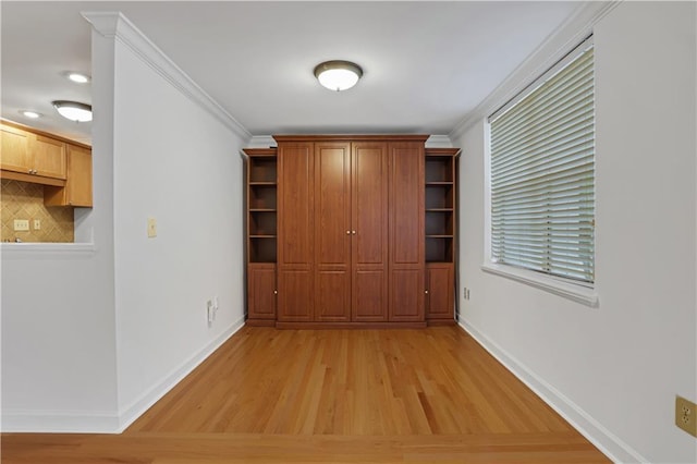 interior space featuring ornamental molding, baseboards, and light wood-type flooring