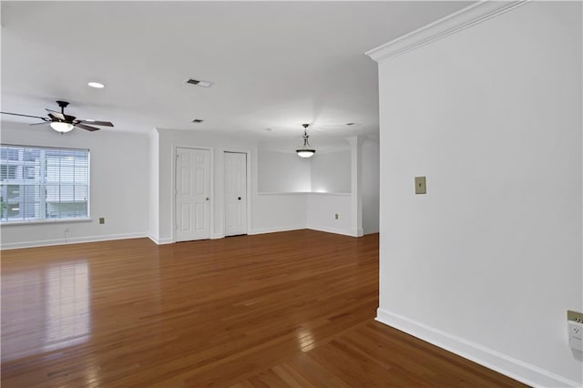 unfurnished living room featuring ceiling fan, wood finished floors, and baseboards