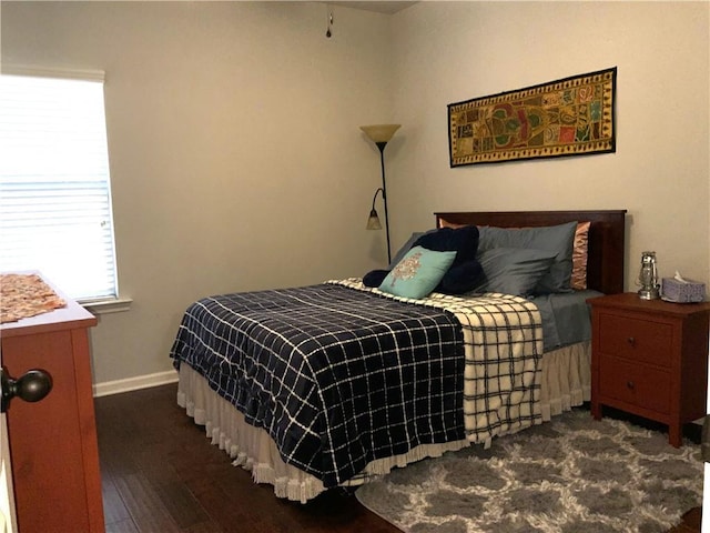 bedroom featuring dark wood-style flooring and baseboards