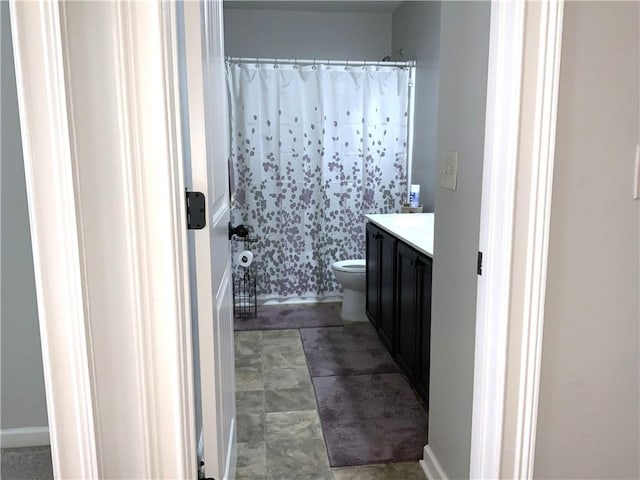 bathroom featuring toilet, shower / bathtub combination with curtain, and vanity