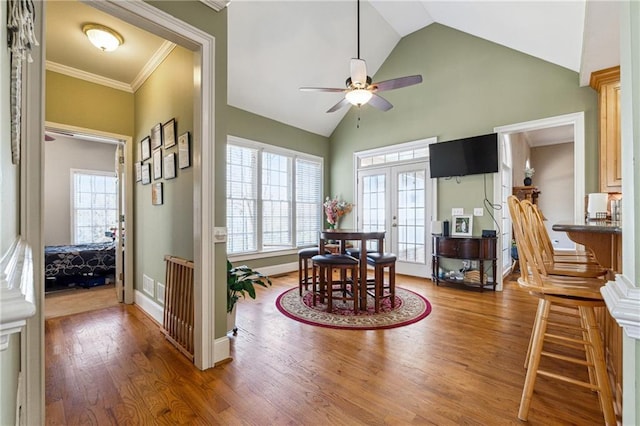 dining area with french doors, crown molding, a ceiling fan, wood finished floors, and baseboards