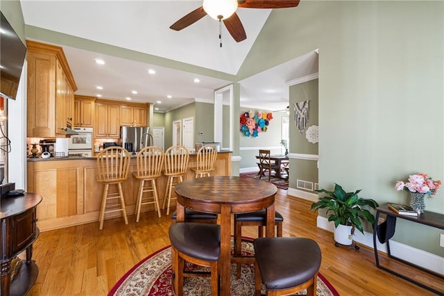 dining area featuring light wood-type flooring, visible vents, and baseboards