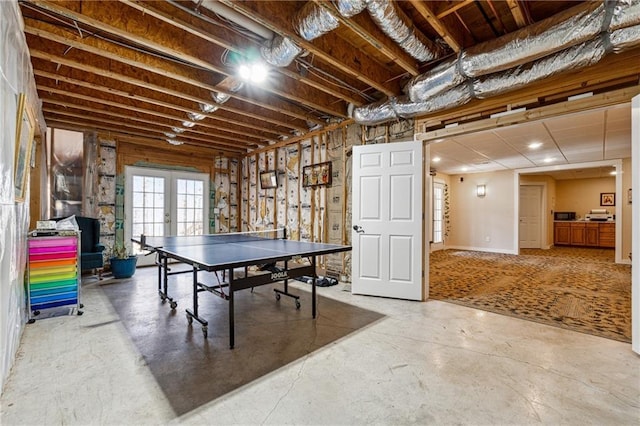 game room featuring french doors and concrete floors