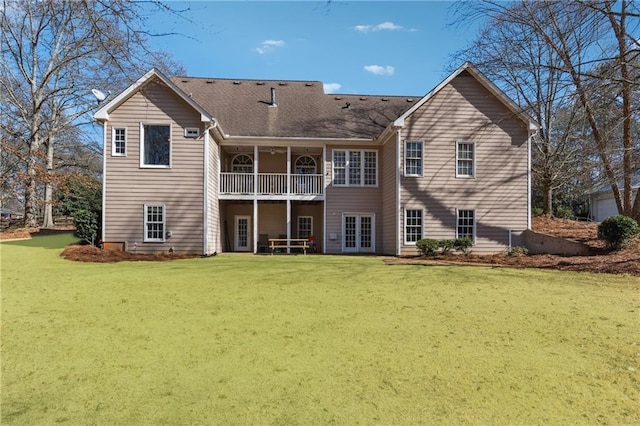 rear view of house with a yard and a balcony