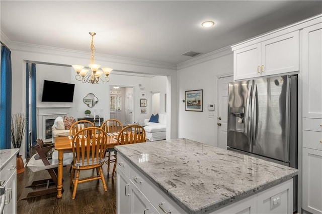 kitchen with visible vents, a fireplace, stainless steel fridge with ice dispenser, dark wood-type flooring, and crown molding