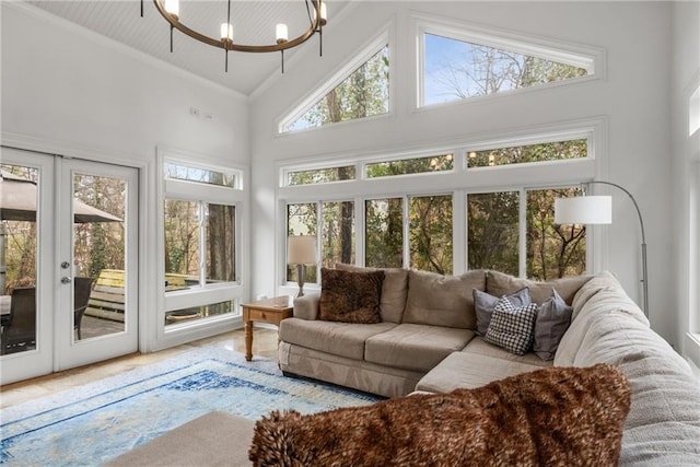 sunroom / solarium featuring an inviting chandelier, french doors, and vaulted ceiling