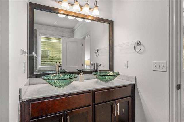 bathroom featuring a sink, ornamental molding, and double vanity