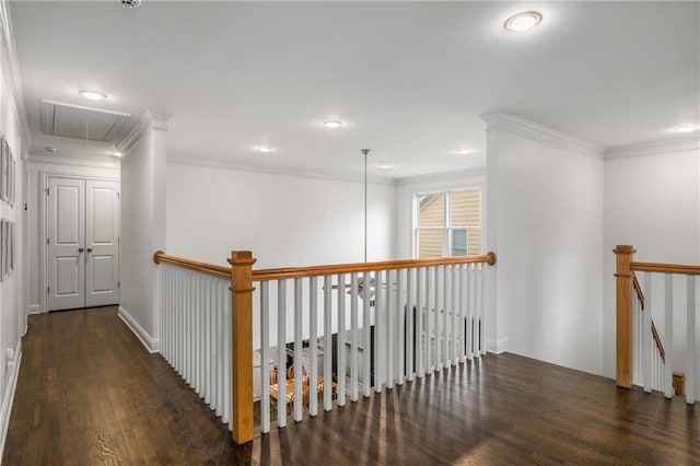 corridor with an upstairs landing, attic access, crown molding, and wood finished floors