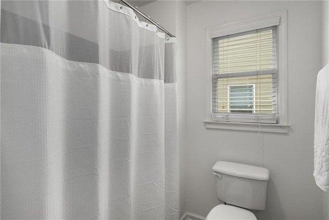 bathroom with curtained shower and toilet