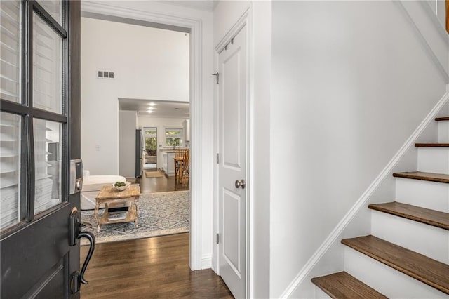 entryway featuring stairway, baseboards, visible vents, and dark wood-style floors