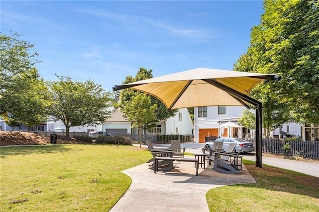 view of community with a patio area, a yard, and fence