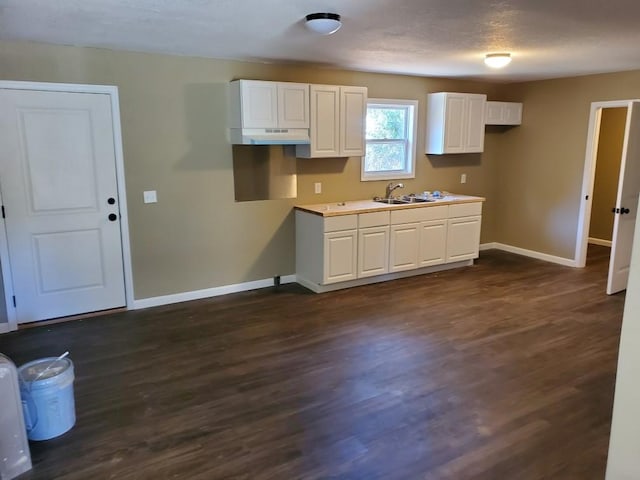 kitchen featuring white cabinetry, sink, dark hardwood / wood-style flooring, and a textured ceiling