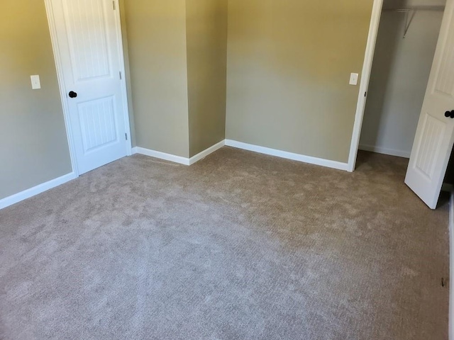 unfurnished bedroom featuring carpet flooring and a closet