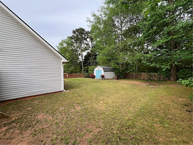 view of yard featuring an outdoor structure, a shed, and fence