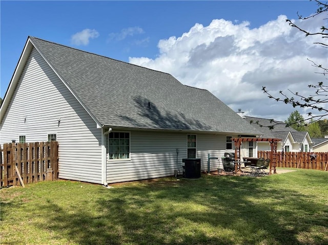 rear view of house featuring a pergola, a fenced backyard, roof with shingles, and a yard