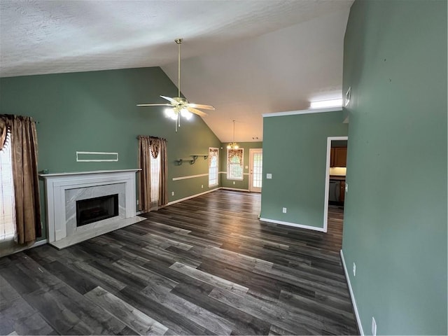 unfurnished living room with high vaulted ceiling, ceiling fan with notable chandelier, a fireplace, baseboards, and dark wood-style floors