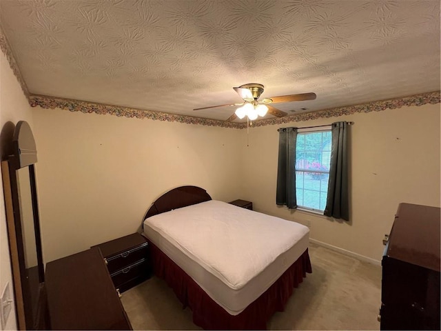 bedroom with baseboards, a ceiling fan, and a textured ceiling