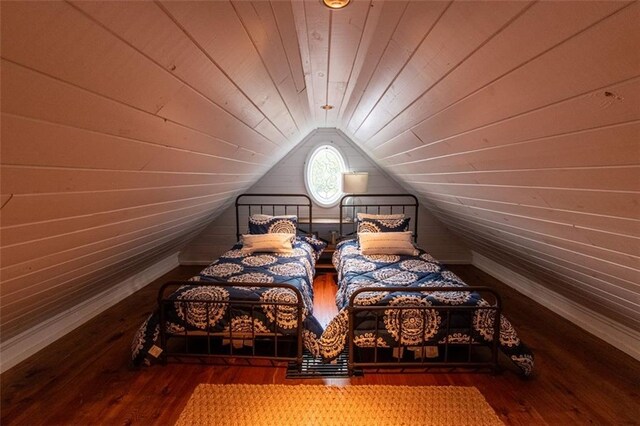 bedroom featuring lofted ceiling, wood walls, dark hardwood / wood-style flooring, and wooden ceiling