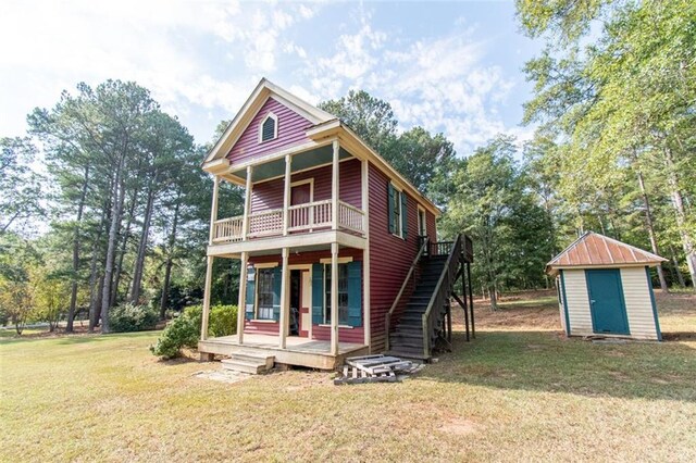 view of front of house with a storage shed and a front yard