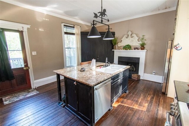 kitchen with appliances with stainless steel finishes, dark hardwood / wood-style flooring, a kitchen bar, decorative light fixtures, and a kitchen island with sink