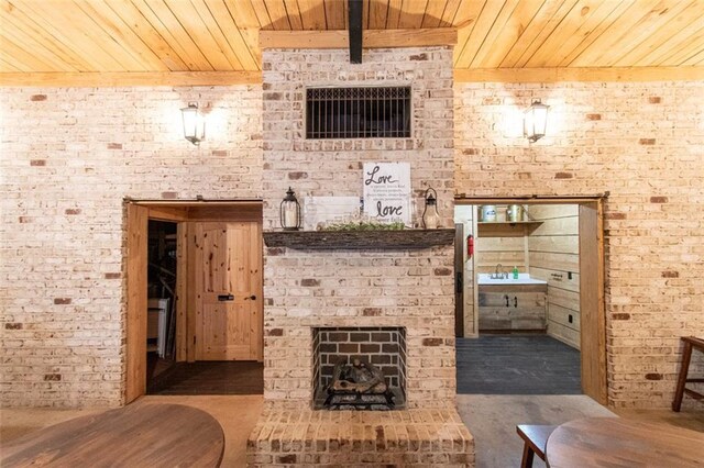 wine room featuring brick wall, beamed ceiling, wood ceiling, and a fireplace