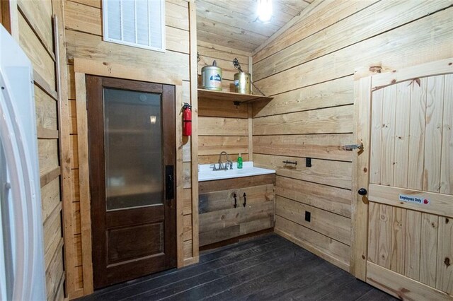 mudroom with wood walls, sink, dark wood-type flooring, wooden ceiling, and vaulted ceiling