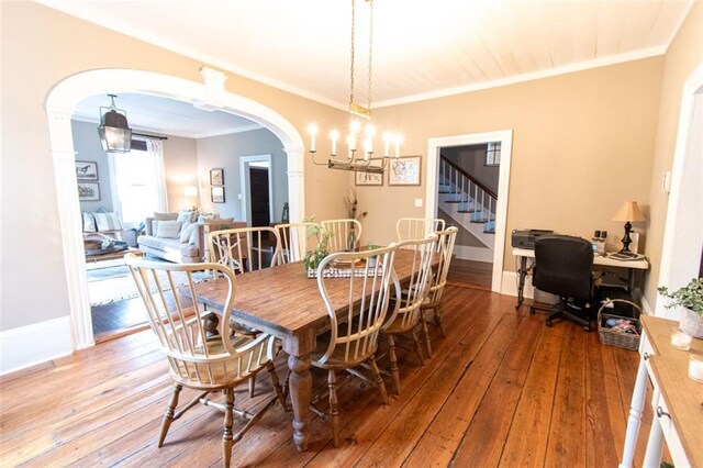 dining space featuring ornamental molding, hardwood / wood-style floors, and a notable chandelier