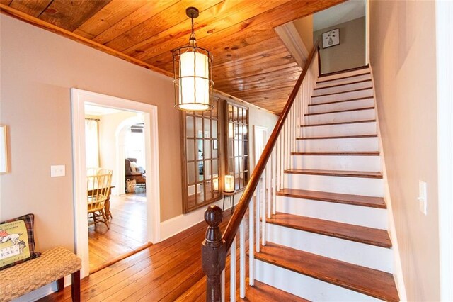 stairway with wooden ceiling and hardwood / wood-style floors